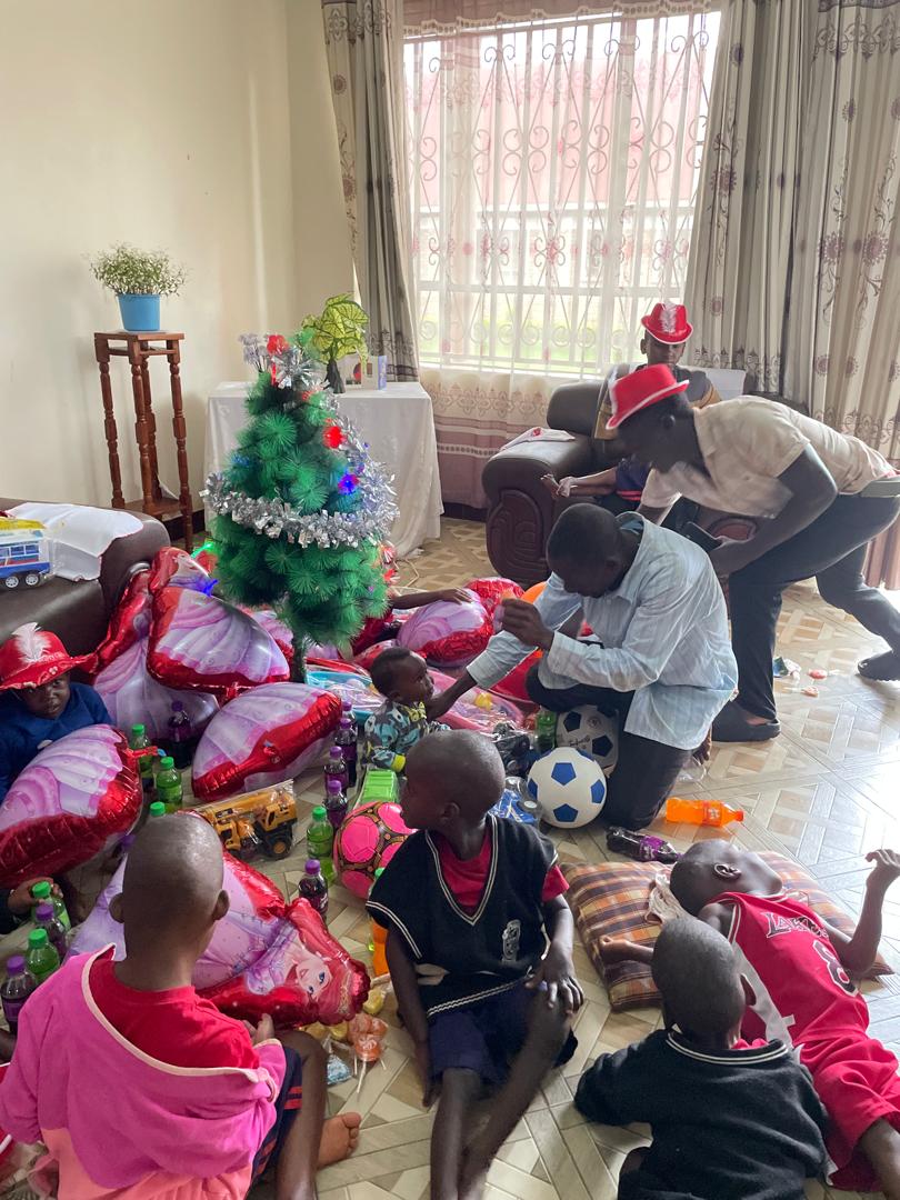 celebración de los santos inocentes en palloti niños y adultos rodeados de regalos y un pequeño arbol de navidad