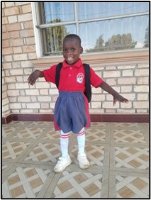 Niño con discapacidad listo para ir a la escuela en Uganda.