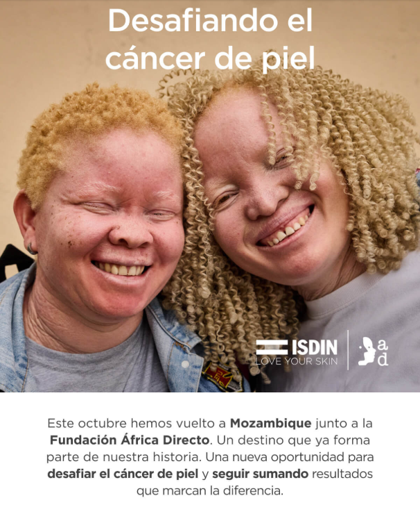 Dos personas con cabello rubio rizado posan juntas, mostrando cercanía. Texto sobre la imagen: “Desafiando el cáncer de piel”. Logotipos de ISDIN y Fundación África Directo. Texto inferior: “Este octubre hemos vuelto a Mozambique junto a la Fundación África Directo… Una nueva oportunidad para desafiar el cáncer de piel y seguir sumando resultados que marcan la diferencia”.